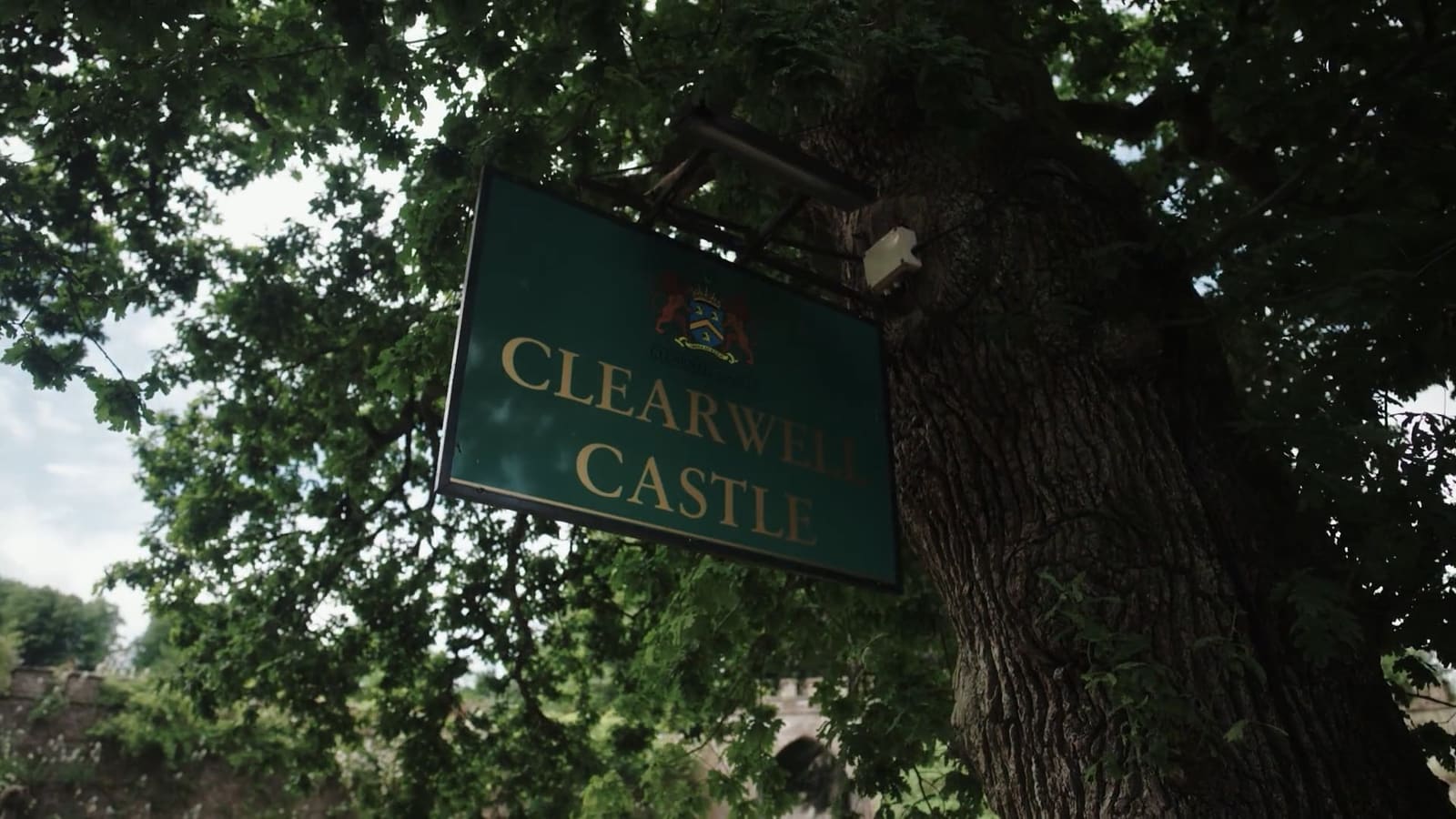 The Clearwell Castle sign hanging from a tree in the village.